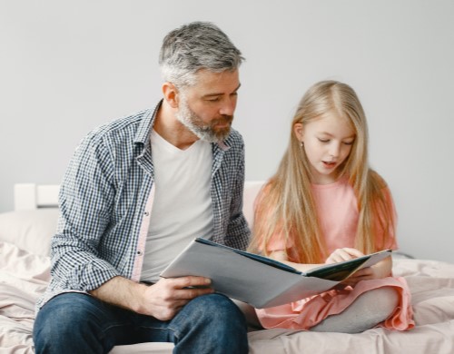 Homeschool father and daughter reading together