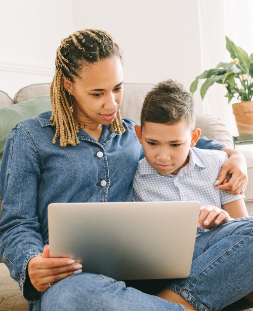 mother and child viewing the Footprints course website on a laptop