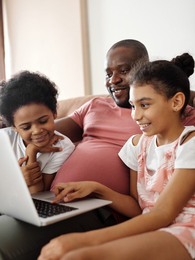 Father and two children using a laptop