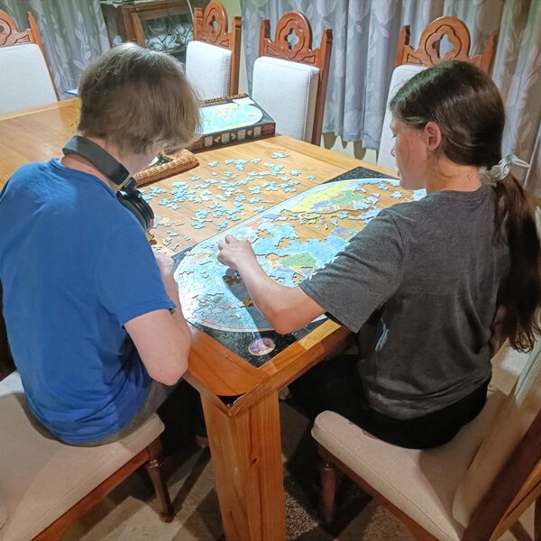 Homeschoolers building a world map puzzle to learn Geography in a Charlotte Mason homeschool.